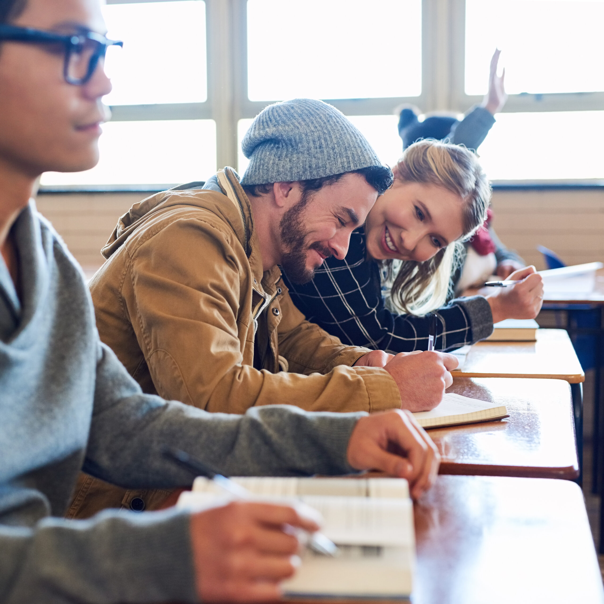 Cropped shot of a group of university students working in class while sitting in a lecture.